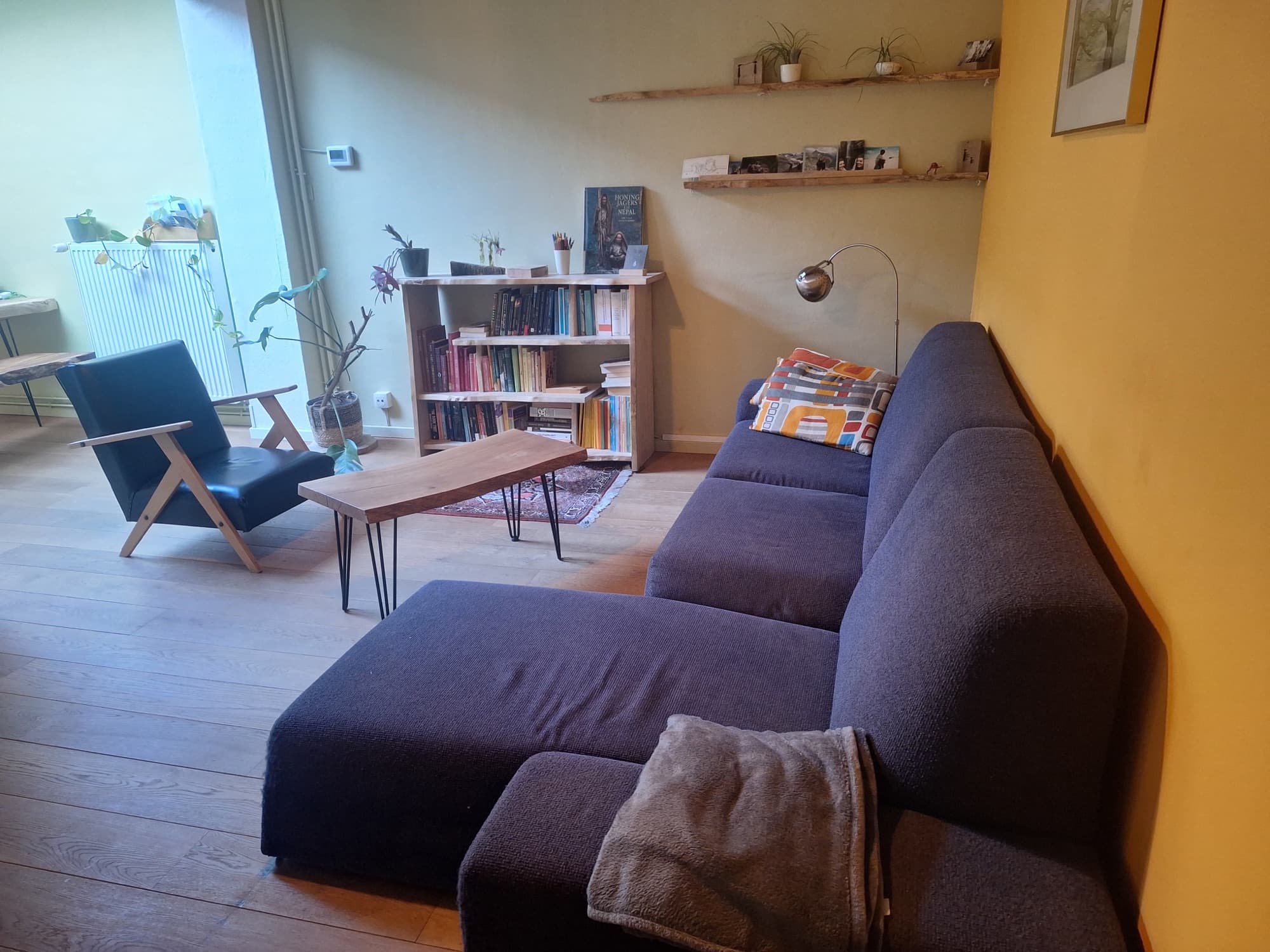 Hoek van de praktijkruimte met leeslamp en boekenkast